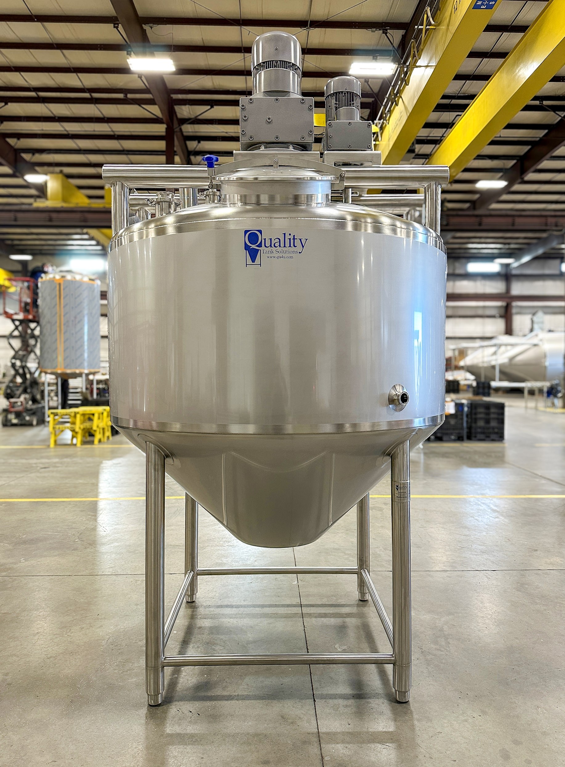 2 agitators on top of a stainless steel processing tank with manway